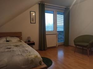 een slaapkamer met een bed, een stoel en een raam bij Apartments Skok in Bled