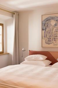 a bedroom with a bed with white sheets and a window at Kai 36 - Hotel zwischen Fels und Fluss in Graz