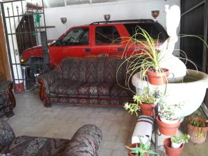 salon z kanapą i czerwoną ciężarówką w obiekcie Casa Santita Por Habitación w mieście Tule