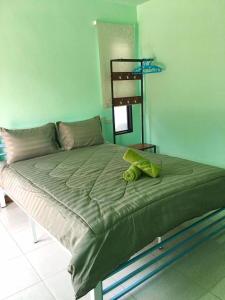 uma cama num quarto com uma parede verde em KOOK BUNGALOW em Ko Mook