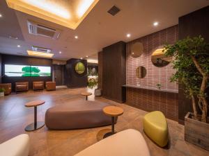 a lobby with a waiting area with stools and a table at Super Hotel Premier Kanazawaeki Higashiguchi in Kanazawa
