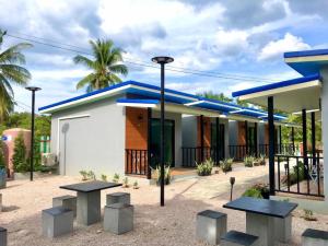 a building with blue roofs and benches in front of it at KOOK BUNGALOW in Ko Mook