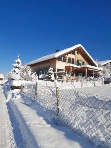 uma cerca em frente a uma casa coberta de neve em Rosanna em Egg