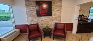 a restaurant with three chairs and a table and a sign at Red Roof Inn Tifton in Tifton