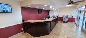 a bar in a restaurant with a red wall at Red Roof Inn Tifton in Tifton