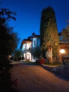 una casa por la noche con una entrada iluminada en Le Zampolle B & B, en Colà di Lazise