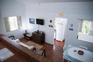 ein Wohnzimmer mit einem Sofa und einem TV in der Unterkunft Chalet in Viamão