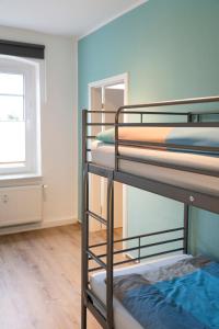 a room with three bunk beds and a window at Harzquartier in Friedrichsbrunn
