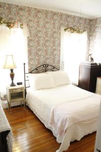 a bedroom with a bed and a wall with floral wallpaper at The Coolidge Corner Guest House: A Brookline Bed and Breakfast in Brookline