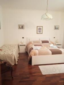 1 dormitorio con 2 camas y pared blanca en B&B le Villette Predappio, en Predappio