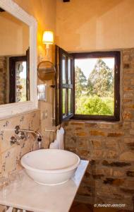 a bathroom with a sink and two windows at La Casa de Campo I in Lamuño