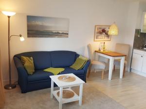ein Wohnzimmer mit einem blauen Sofa und einem Tisch in der Unterkunft Sylter Flunder in Westerland