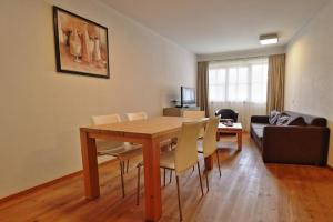 salon z drewnianym stołem i krzesłami w obiekcie Panorama Chalet w mieście Mittersill