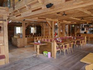 un restaurante con paredes de madera, mesas y sillas en Panorama Chalet en Mittersill
