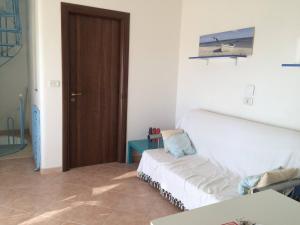 un soggiorno con divano bianco e porta in legno di Villa Nicole - NP a Punta Prosciutto