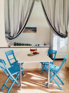 un tavolo bianco con sedie e tende in una stanza di Villa Nicole - NP a Punta Prosciutto