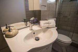 ein Badezimmer mit Waschbecken, Toilette und Spiegel in der Unterkunft Kristy's Place in Crikvenica + 19 Fotos