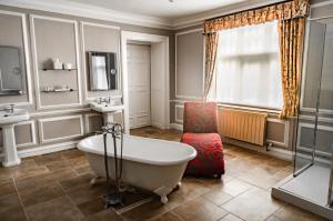 a bathroom with a bath tub and a sink at Castle Bromwich Hall; Sure Hotel Collection by Best Western in Birmingham