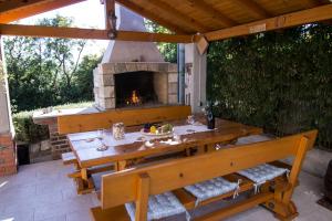a table and benches on a patio with a fireplace at Kristy's Place in Crikvenica