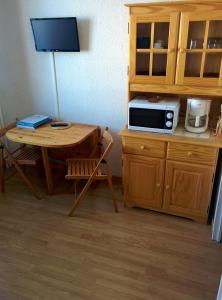 a kitchen with a table and a microwave on a counter at Appartement d'une chambre avec jardin clos et wifi a La Salle les Alpes in La Salle Les Alpes