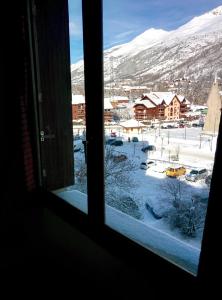 a window with a view of a snow covered town at Appartement d'une chambre avec jardin clos et wifi a La Salle les Alpes in La Salle Les Alpes