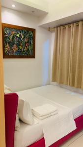 a bed in a room with a painting on the wall at The Wind Escape Netflix-Ready Staycation for 4 in Tagaytay +24 photos