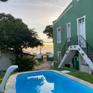 a house with a swimming pool in front of a house at Vila Casarão Verde in Itacaré