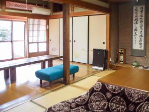 een woonkamer met een tafel en een blauwe stoel bij Shingu Guest House 奏 in Shingu