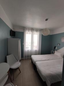 een slaapkamer met 2 bedden, een tafel en een raam bij Abrivado in Saintes-Maries-de-la-Mer
