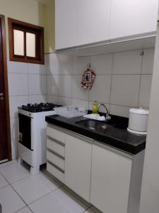 a small kitchen with a sink and a stove at Chalé para temporada no Centro de Guaramiranga in Guaramiranga