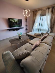 uma sala de estar com 2 sofás e uma televisão de ecrã plano em Royal Resort em Eilat