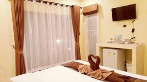 Serene Lanta Resort في كو لانتا: غرفة نوم مع سرير مع دمية دب عليها