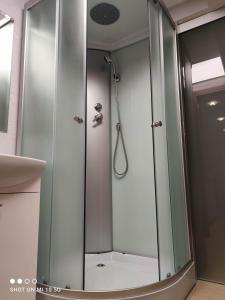 a shower with a glass door in a bathroom at New York apartament by Karl in Radom