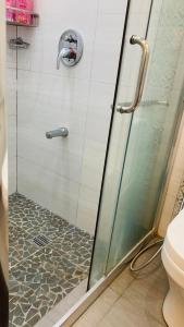 a shower with a glass door in a bathroom at Son's Condo SMDC Wind Tagaytay in Tagaytay