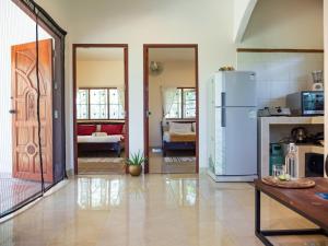 a kitchen with a refrigerator and a living room at Tropical Home Koh Phangan in Thongsala