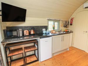 a kitchen with a counter with a microwave and a sink at Badger in Keighley