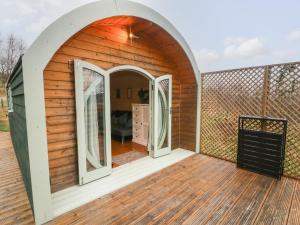 una casa in legno con una porta ad arco su una terrazza di Badger a Keighley