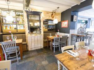 um restaurante com mesas e cadeiras e um bar em The Plough Bicester em Bicester