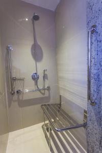 a shower stall with a bench in a bathroom at Holiday Inn Natal, an IHG Hotel in Natal