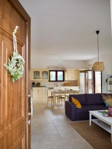 sala de estar con sofá azul y cocina en Villa Filia en Gennadi