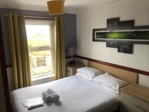 a small bedroom with a bed with a window at Boathouse Hotel in Holyhead