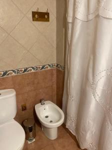 Un baño con inodoro y cortina de ducha. en Complejo Frente al Golf, en Pinamar 143 fotos más