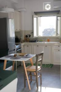 a kitchen with a table and chairs and a refrigerator at Casa Di Volto in Skaládhos