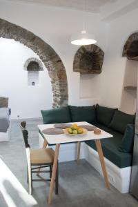 Casa Di Volto في Skaládhos: غرفة معيشة مع أريكة خضراء وطاولة