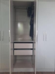 un vestidor blanco con armarios blancos en Charmosa casa em condominio com quintal en São Paulo