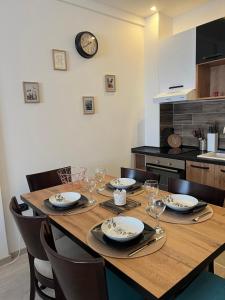 einen Esstisch mit Stühlen und eine Uhr an der Wand in der Unterkunft Milmari Apartman Haski N55 in Kopaonik