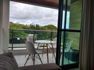 a balcony with a table and chairs on it at Apartamento quarto e sala - Iloa Residence II in Barra de São Miguel