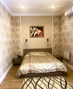 1 dormitorio con 1 cama y una pintura en la pared en Hotel Karavan, en Petrozavodsk