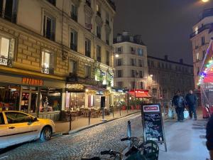 une rue de la ville la nuit avec une voiture garée dans la rue dans l'établissement Grand Hôtel de Clermont, à Paris