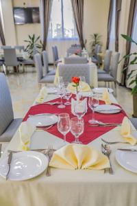 una mesa con platos y copas de vino. en Roseau Hotel And Spa, en Gondar